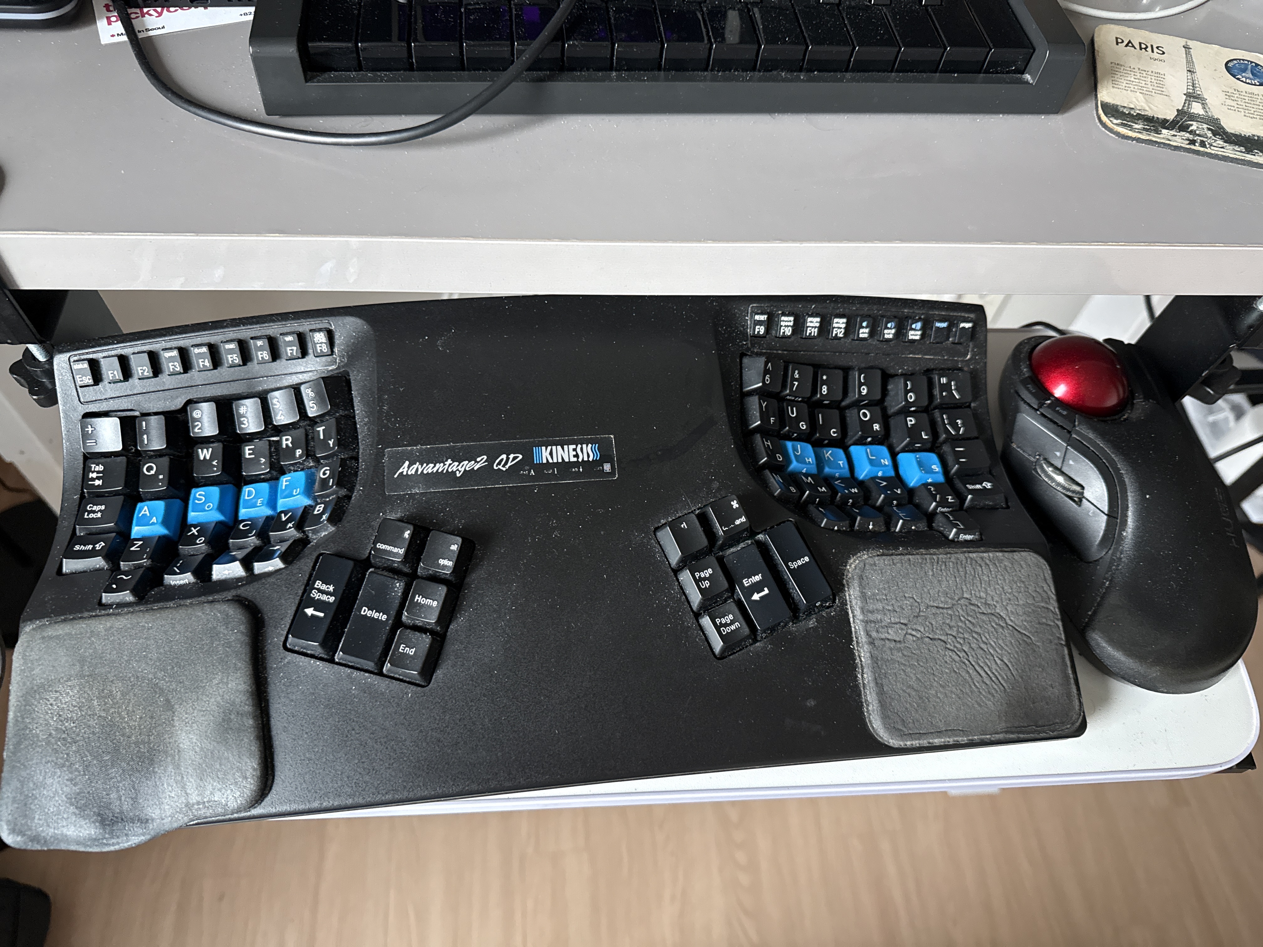 An Elecom HUGE trackball, with the side hanging off the edge of a white keyboard tray
